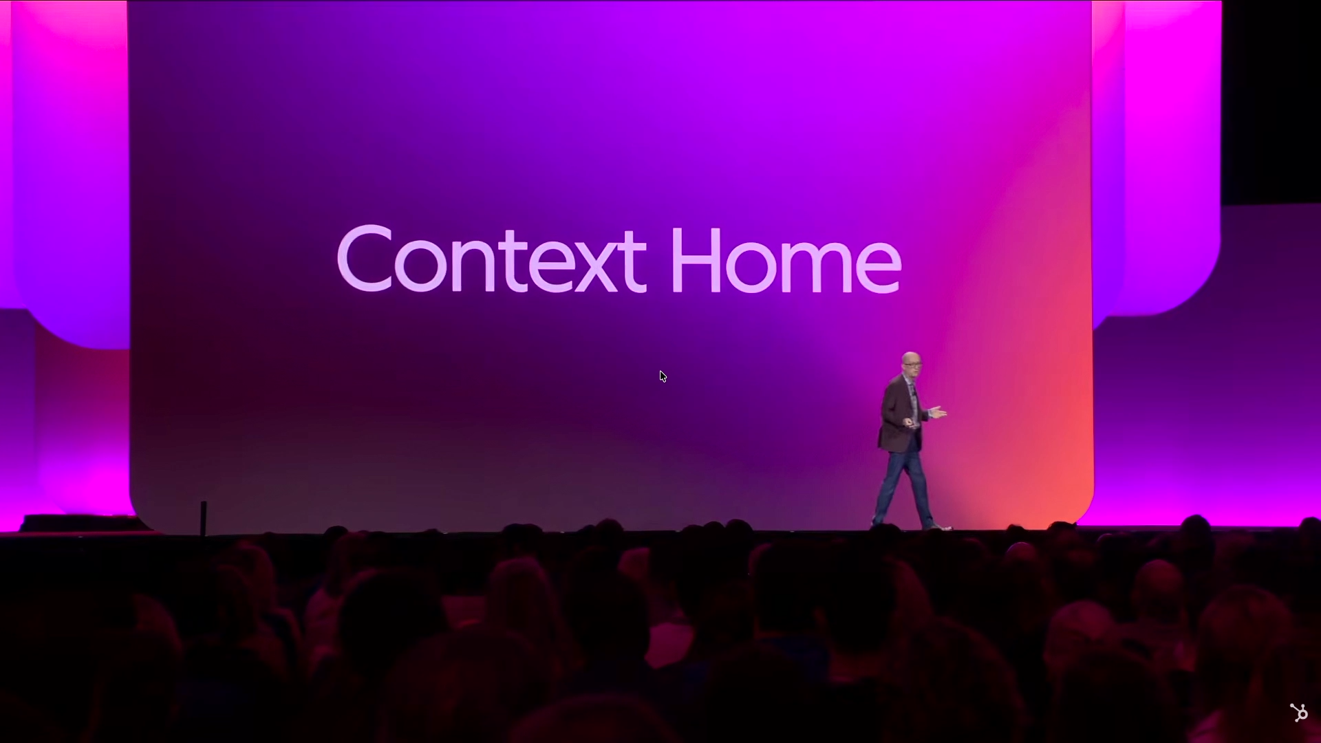 Stage backdrop with the text Context Home in large white letters and the speaker standing in front