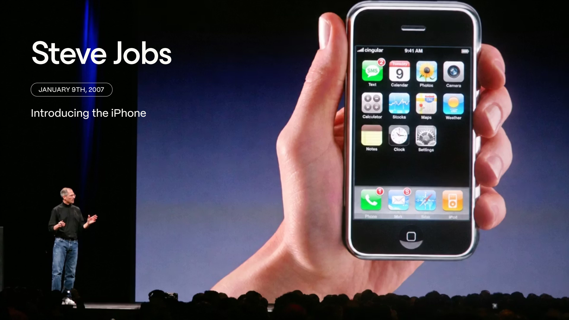 Steve Jobs on stage beside a giant projected image of an iPhone held in a hand