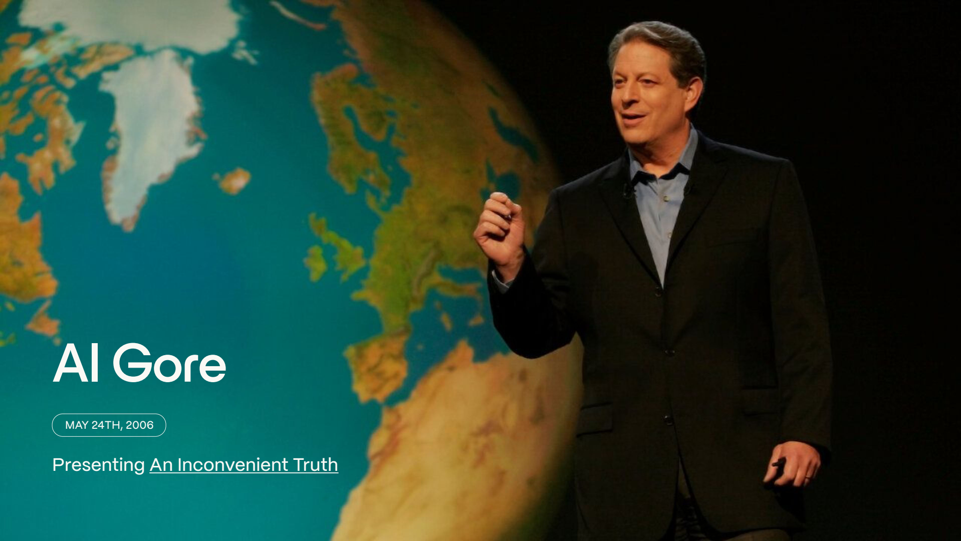 Al Gore standing on stage in front of a large projected image of the Earth
